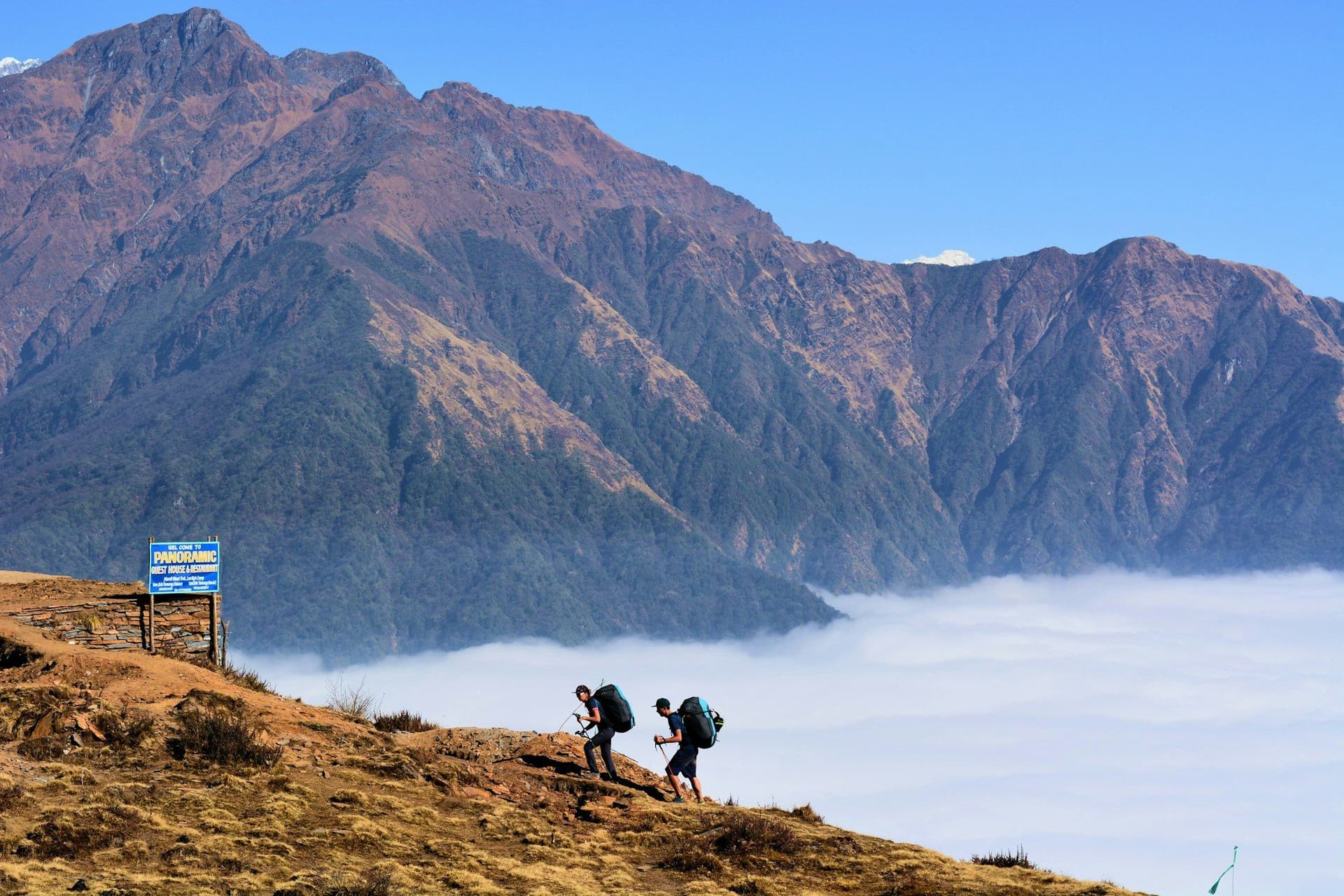 Two trekkers on a ridge above a sea of cloud