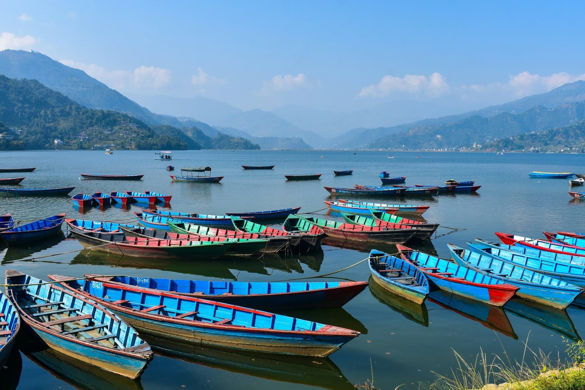 Painted wooden boats moored along the lakeshore