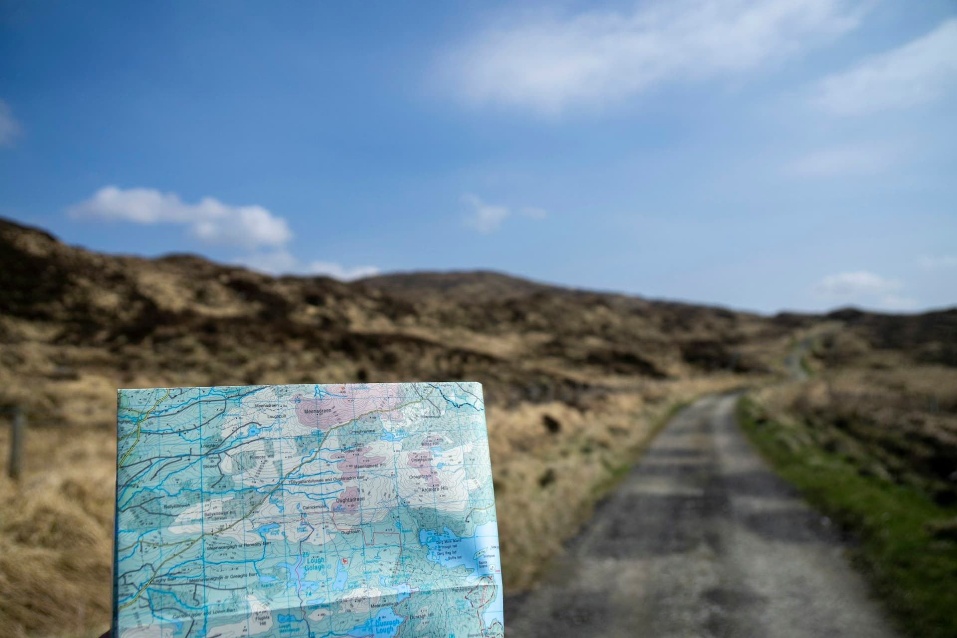 A folded paper map open on a rock beside the trail