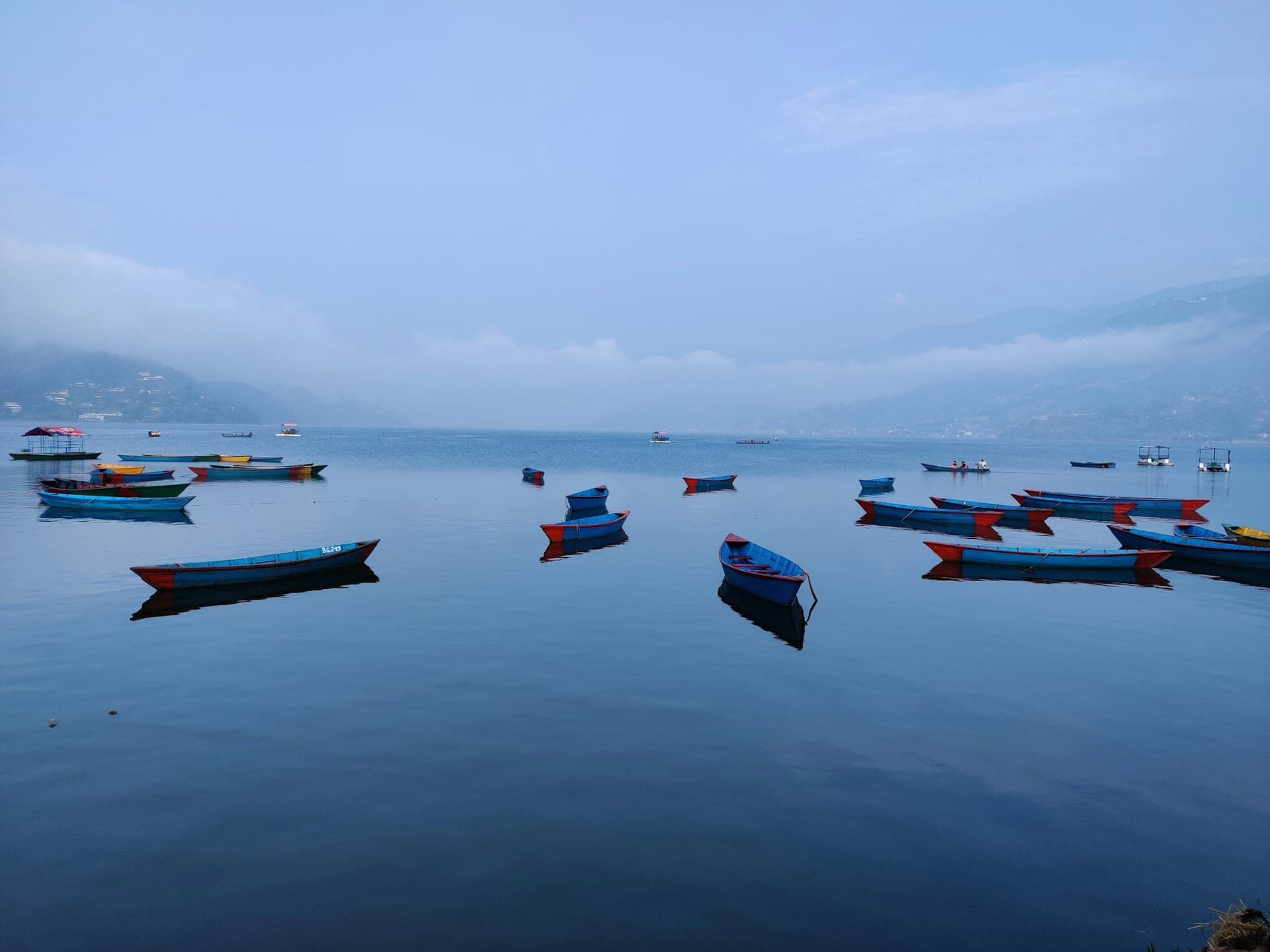 Wooden boats moored on a still lake in the morning