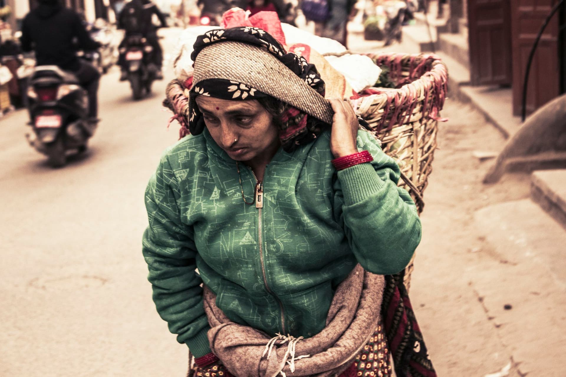 A load carried in a woven doko basket along a hill road