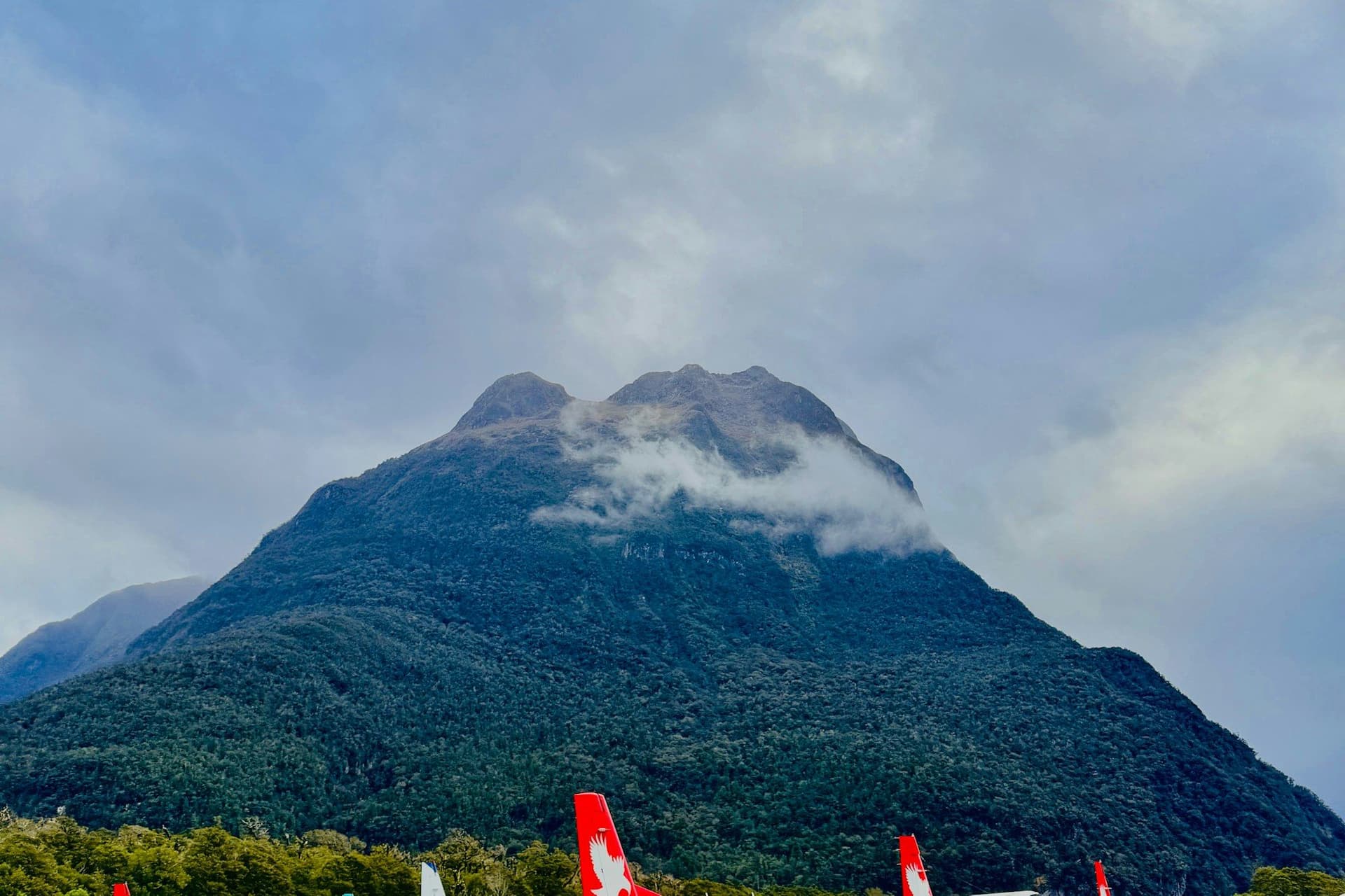 Small aircraft parked on a mountain airstrip below cloud